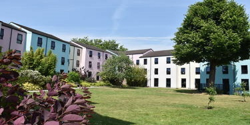 A green space surrounded by colourful residential buildings at Manor Hall.